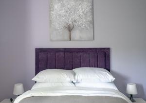 een slaapkamer met een bed met witte lakens en een boom bij One bedroom Flat Free Parking in Londen