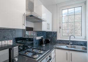 a kitchen with a stove and a sink and a window at One bedroom Flat Free Parking in London