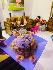 una persona che tiene una torta su un piatto blu di SAKURA Guest House tourist only a Wariyapola