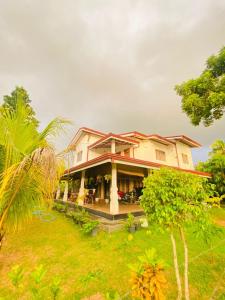 uma casa com uma palmeira em frente em SAKURA Guest House tourist only em Wariyapola