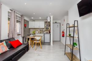a living room with a black couch and a kitchen at Mia guest House R/C in Setúbal