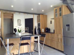 a kitchen with a refrigerator and a table and chairs at Les Co Gîte in Vigny