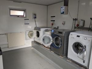 lavadero con 3 lavadoras y lavadora y secadora en Stacaravan Il Piccolo Nido in bosrijke omgeving Eext, en Eext