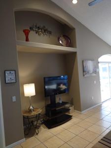 sala de estar con TV de pantalla plana en la pared en Florida Villa, en Kissimmee