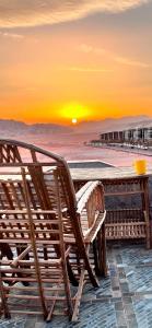 a table and chairs on the beach at sunset at Wadi Rum Sky Tours & Camp in Wadi Rum