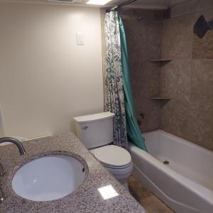 a bathroom with a sink and a toilet and a tub at Venture Gateway to National Parks & BYUI in Saint Anthony