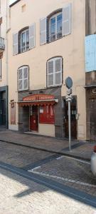 un edificio con una puerta roja en una calle en Le Cosy Montferrandais, en Clermont-Ferrand
