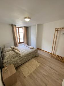 Un dormitorio con una cama y suelo de madera. en Le Cosy Montferrandais, en Clermont-Ferrand