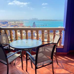 a table and chairs on a balcony with a view of the ocean at شاليه في بورتو مارينا الساحل الشمالي العلمين 59 in El Alamein