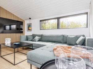 een woonkamer met een bank en een tafel bij Holiday home Løgstør IX in Løgsted