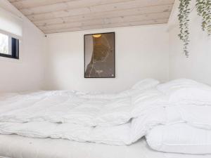 a white bed in a white room with a picture at 4 star holiday home in Løgstør-By Traum in Løgsted