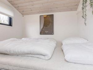twee bedden in een kamer met witte muren bij Holiday home Løgstør IX in Løgsted