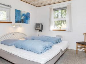 Un dormitorio con una cama con almohadas azules. en Holiday home Højslev IV, en Højslev