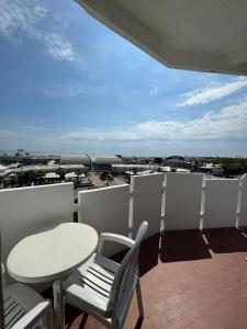 balcón con mesa, sillas y vistas a la ciudad en Hotel Ariston, en Sottomarina