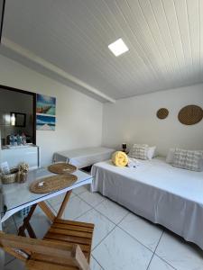 a room with two beds and a table in it at Flor do Mar - bed and breakfast in Santa Cruz