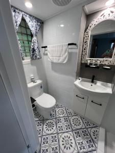 a bathroom with a toilet and a sink at Rainbows End in Redcliffe