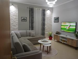 a living room with a couch and a tv at Muska Comfy Apartment in Berat