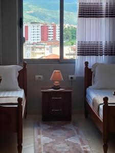 a bedroom with two beds and a lamp on a night stand at Muska Comfy Apartment in Berat +19 photos