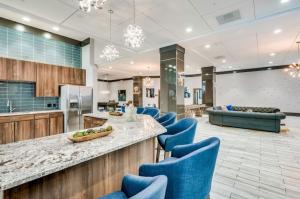 a lobby with blue chairs and a counter and a kitchen at Houston Getaway in Houston