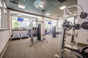 a gym with cardio equipment in a building at Houston Getaway in Houston