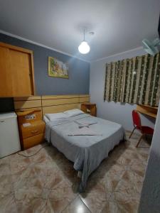 聖保羅的住宿－Hotel Mooca，卧室配有1张床、1张桌子和1把椅子