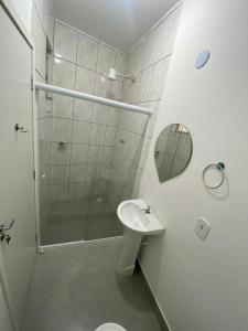 biała łazienka z prysznicem i umywalką w obiekcie Pousada e Espaco AURORA Peruibe w mieście Peruíbe