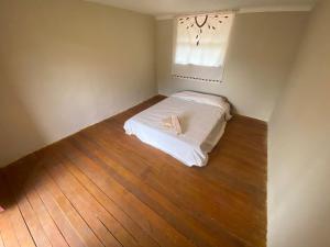 una piccola camera con letto bianco e pavimento in legno di Wallpari Sonqo Hospedaje Medicina temazcal a Písac