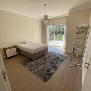 1 dormitorio con cama y ventana grande en Casa de campo espetacular condomínio a 50min de SP en Itupeva