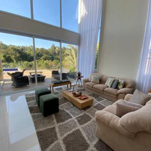 uma sala de estar com sofás e uma grande janela em Casa de campo espetacular condomínio a 50min de SP em Itupeva