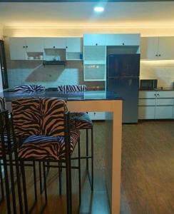 a kitchen with a counter and two chairs at a table at The Keza Hotel Botique in Kigali