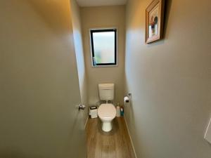 Un baño con inodoro y ventana. en 23 St James Avenue, en Hanmer Springs