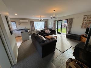 una sala de estar con un sofá y una mesa en 23 St James Avenue, en Hanmer Springs