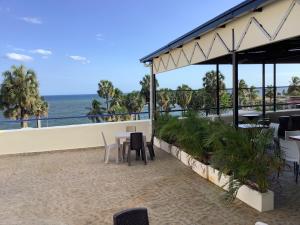 a restaurant with a table and chairs and the ocean at Hotel Blue Malecón And Spa in Santo Domingo