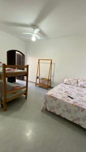 - une chambre avec un lit et une table dans l'établissement Pousada e Espaco AURORA Peruibe, à Peruíbe