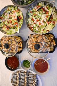 a table topped with different types of food and dips at Tequila Sunrise Hostel Surfers Paradise in Gold Coast