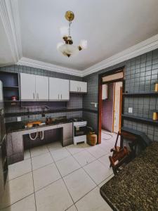 a kitchen with white cabinets and a tile floor at Diamantina Palace Hotel in Morro do Chapéu