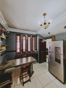 a kitchen with a stainless steel refrigerator and a table at Diamantina Palace Hotel in Morro do Chapéu
