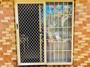 una finestra con cancello su un edificio di mattoni di Granny flat a Brisbane