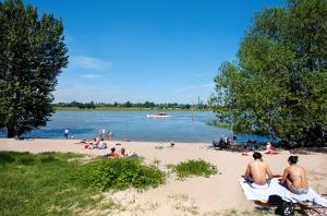 a group of people sitting on the sand at a beach at Square Rooms 8 in Düsseldorf