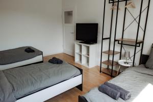 a living room with two beds and a television at 5 Bett-Wohnung in guter Lage von Geilenkirchen in Geilenkirchen