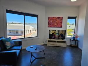 a living room with a couch and a tv at Aart Apartments in Port Lincoln
