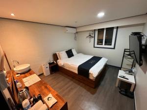 Dormitorio pequeño con cama y mesa en Hotel Luna Hanok Village en Jeonju