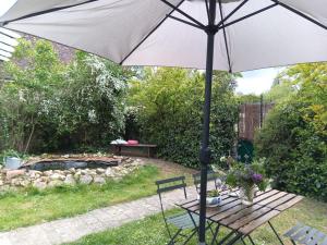 an umbrella sitting next to a table and a bench at Art Cottage in Pontlevoy