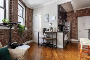 uma sala de estar com uma parede de tijolos em Room at the heart of East Village 2 em Nova York