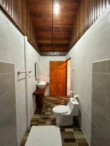 a bathroom with a toilet and a sink at Arenal Rústic Lodge in Fortuna