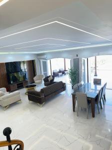 un salon avec des canapés, une table et des chaises dans l'établissement فيلا7غرف اول صف على البحر بحمام السباحة مارينا 5 الساحل الشمالي العلمين, à El Alamein