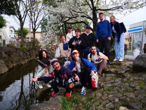 een groep mensen die poseren voor een foto naast een rivier bij MAKOTO GUESTHOUSE -Enjoy your stay- in Tokyo