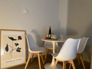 stół, 4 krzesła i butelkę wina w obiekcie West Comfort - near Agia Marina metro w Atenach