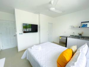 Dormitorio blanco con cama con almohadas amarillas en Magico Apartaestudio con Piscina 1 Habitacion PR29 en Montería