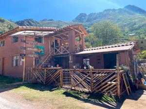 a building with a wooden fence in front of it at Wallpari Sonqo Hospedaje Medicina temazcal in Pisac